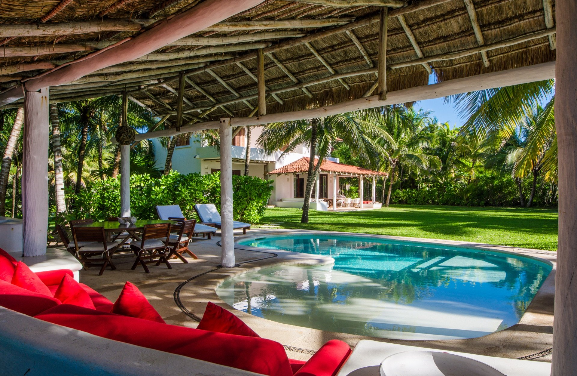 Terraza con piscina rodeada de vegetación tropical